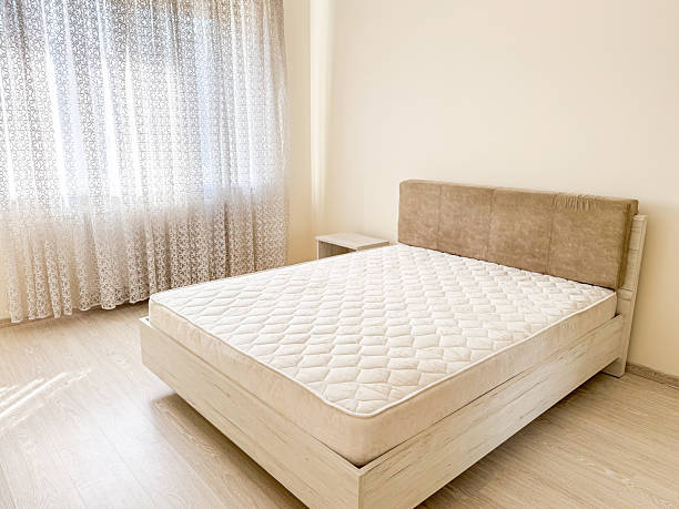 istock bedroom features a double bed with a quilted mattress, soft headboard, and sheer curtains 2209038995