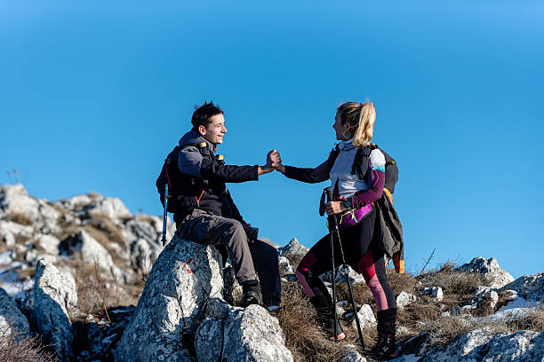 istock Hikers exchanging greetings atop a mountain amid a bright blue sky 2209039262