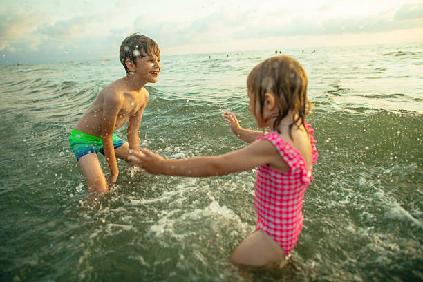 Little boy and girl playing in the sea