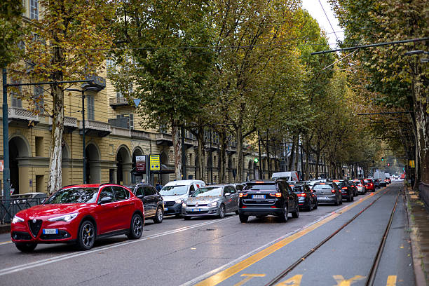 Turin, Italy - Nov 10 2021: Traffic jam on a city street lined with autumn trees.