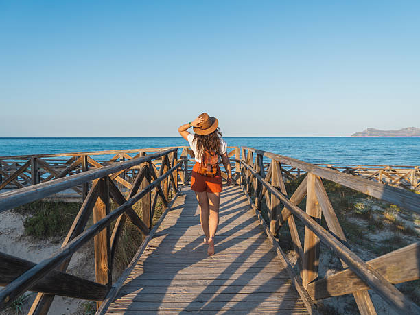 istock Woman Walking on Wooden Path Toward Mediterranean Beach in Mallorca 2209041008