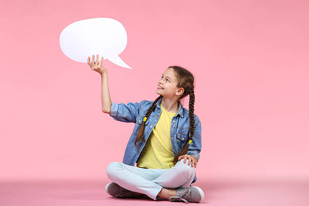 istock Young girl with speech bubble on pink background 2209041550
