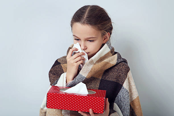 istock Young sick girl with handkerchief on grey background 2209044757
