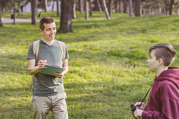 istock Father and son bonding thorough the same outdoor hobby. They are spending their free weekends at national park to watch and explore birds, insects and plants. 2209044982