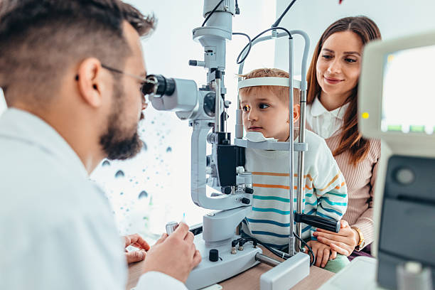 istock Optometrist Examining Young Child's Eyes with Specialized Equipment in Clinic 2209045116
