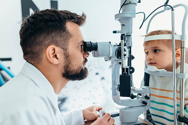 istock Optometrist Examining Young Child's Eyes with Specialized Equipment in Clinic 2209045117