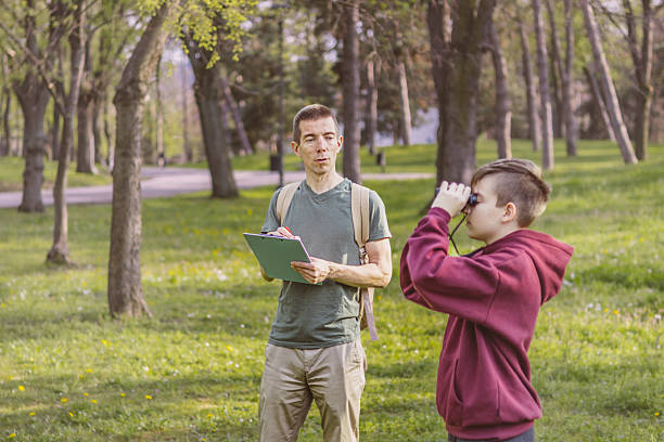 istock Father and son bonding thorough the same outdoor hobby. They are spending their free weekends at national park to watch and explore birds, insects and plants. 2209045538