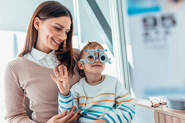 istock Mother and Child at Eye Exam in Bright Optometrist's Office 2209045762
