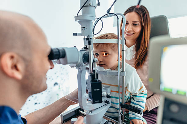 istock Child Undergoing Eye Examination with Optometrist and Smiling Mother 2209045803