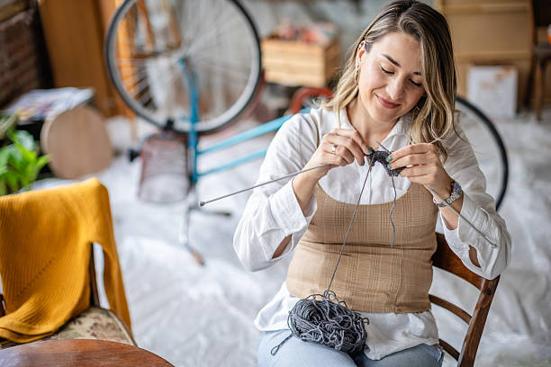 istock Engaging in a creative hobby, a young adult enjoys knitting while surrounded by an inspiring and artistic workspace 2209045820