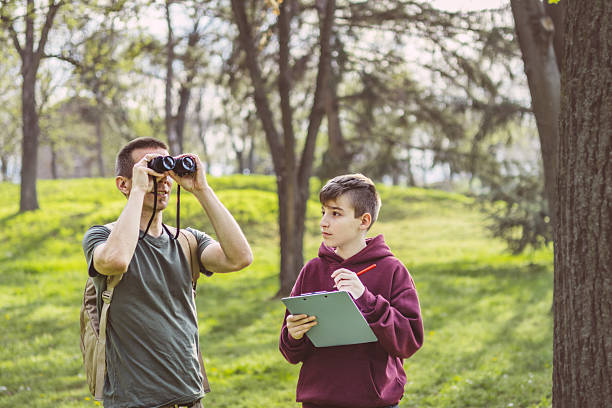 istock Father and son bonding thorough the same outdoor hobby. They are spending their free weekends at national park to watch and explore birds, insects and plants. 2209045865