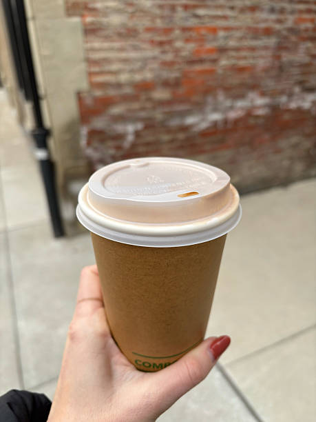 istock Hand Holding Coffee in Street 2209047095