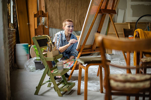 istock Creative adult engaged in artistic expression in a bright studio while working on a canvas 2209047118