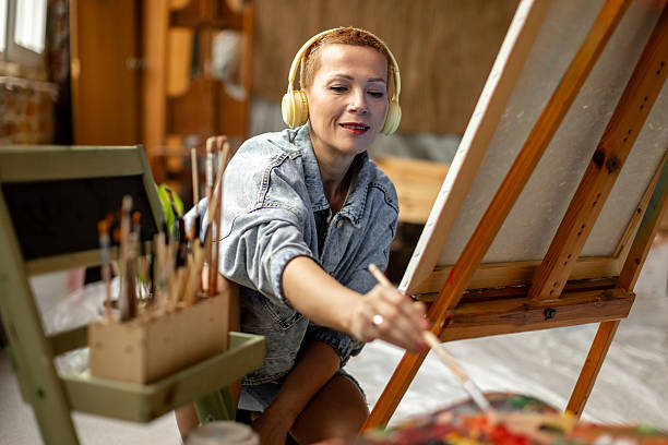 istock Engaging adult artist showcasing creativity in a vibrant indoor studio environment while painting on canvas 2209047302