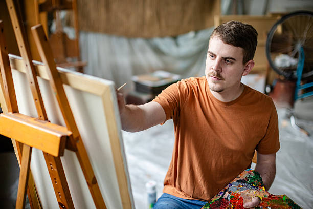 istock Creative adult artist engaging in painting within a vibrant studio workspace during daylight hours 2209049084