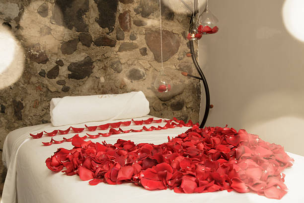 istock Massage table decorated with rose petals in a spa room 2209050245