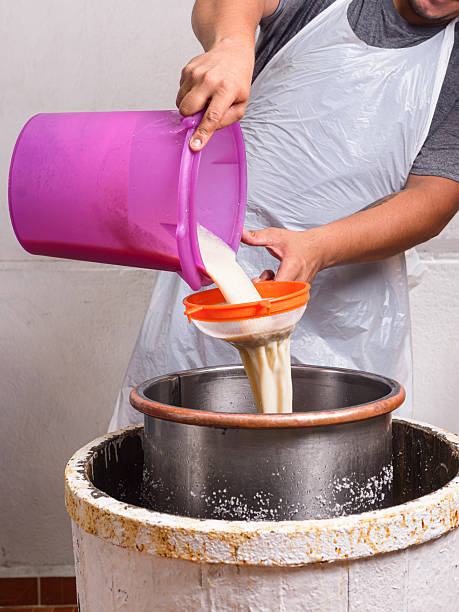 istock Man pours liquid mixture into an antique handmade ice cream maker. Ice cream preparation process 2209054112