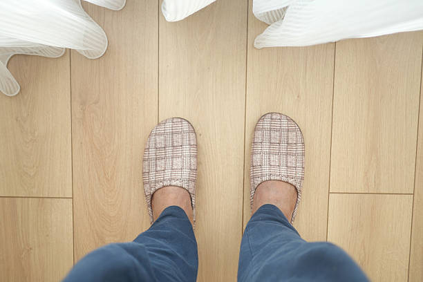 istock Comfortable Cozy Indoor Slippers Resting on a Wooden Floor Surface 2209063010