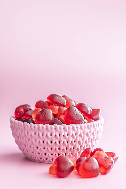 Heart shaped jelly candies on a pink background.