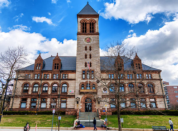 Cambridge, Massachusetts, USA - March 25, 2025: The Cambridge City Hall is the city hall for Cambridge, Massachusetts, located at 795 Massachusetts Avenue, and built in the Richardsonian Romanesque style. The hall was built between 1888 and 1889, and was largely funded through a donation from Frederick Hastings Rindge. Cambridge City Hall houses offices for the city council, the city manager and several municipal departments.