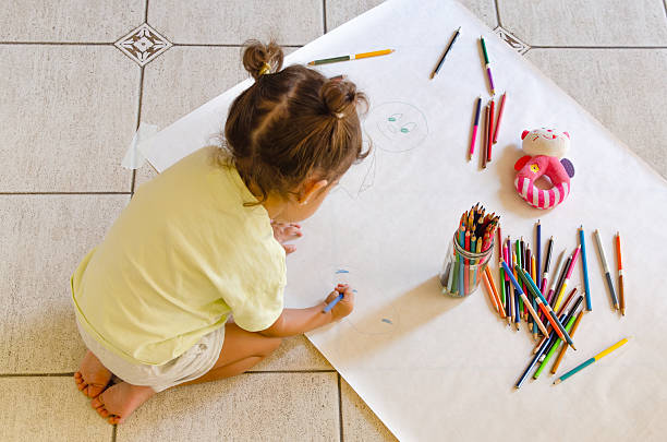 istock A little girl drawing on the floor. 2209069304