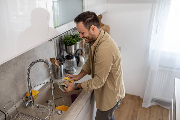 istock Man washing dishes in a modern kitchen 2209071039