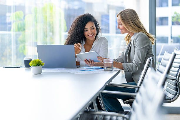 istock Business colleagues having a conversation. They are both young business people casually dressed in a modern office 2209071295