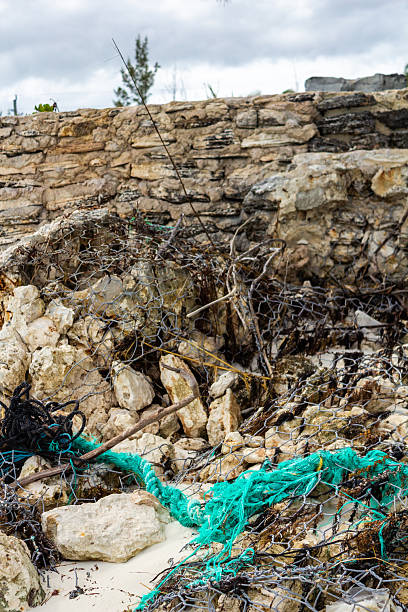 istock Dilapidated Stone Wall with Wires and Litter in Coastal Environment 2209074536