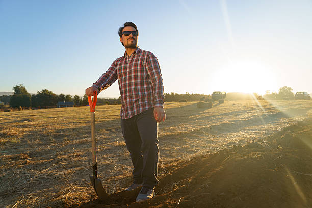 Young latin american farmer taking a break from working the land at sunset