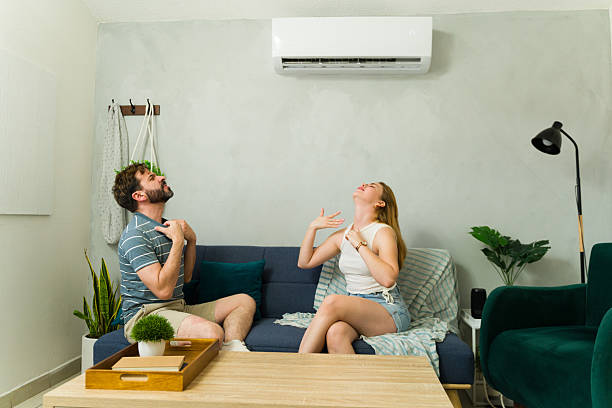 istock Couple feeling uncomfortable at home with air conditioning on a hot summer day 2209077184