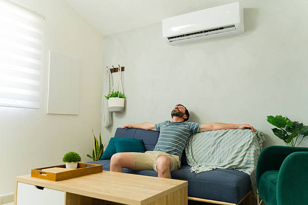 istock Handsome man relaxing on sofa under air conditioning unit at home 2209077476