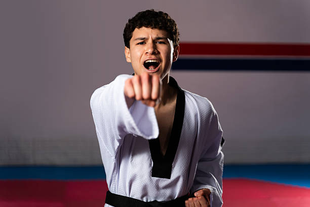 Young taekwondo fighter performing martial arts punching move