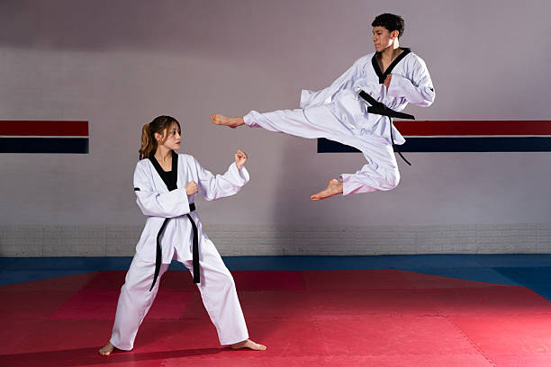 istock Taekwondo fighters training performing a flying kick in gym 2209081892