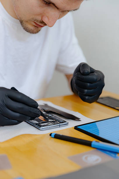 istock A young man repairs a smartphone at home. 2209082021