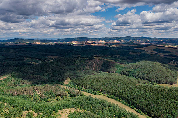 istock Aerial landscape of forested hills and open fields under cloudy sky 2209082788