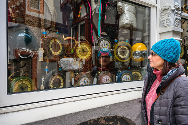 Woman window shops for old clocks in winter