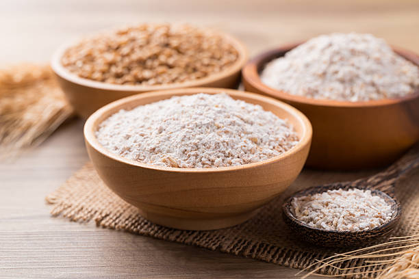 istock Whole wheat flour with wheat grain in bowl on wooden background 2209085461