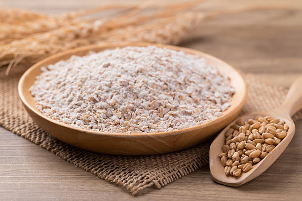istock Whole wheat flour with wheat grain on wooden background 2209085487