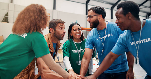 istock Huddle, motivation and support with volunteer team in warehouse together for aid, community or welfare. Charity, donation and stack of hands with people in circle for ngo or non profit success 2209095491