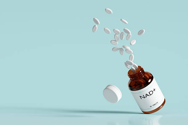 istock Brown glass bottle with NAD+ pills bursting out, set against soft blue background. 2209096496
