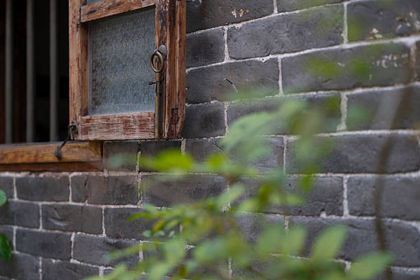 A corner of a wooden window on a gray brick wall