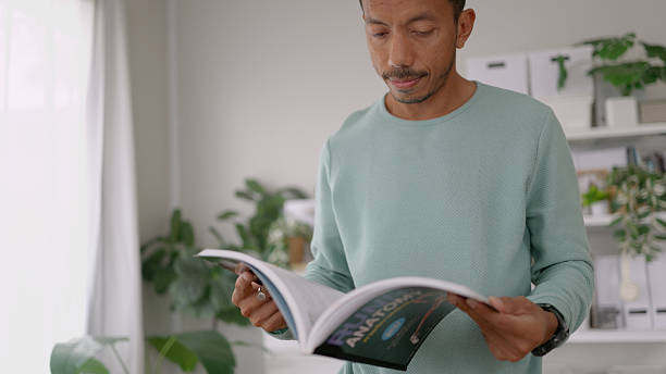 istock Asian man reading a book in the morning. 2209102112