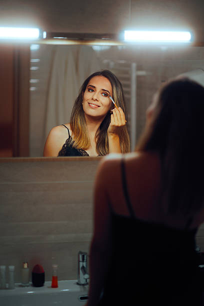 istock Woman Applying Eye Makeup with a Brush in Mirror Getting Ready 2209103247