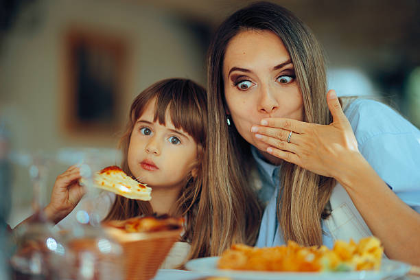 istock Funny Daughter and Mother Having Pizza in a Restaurant 2209104361