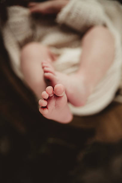 istock Newborn baby feet and toes with copy space 2209104801