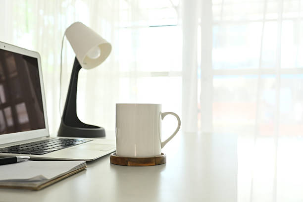 istock A white coffee mug sits on a coaster on a desk next to a laptop. 2209108238
