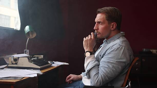 istock Smoke-filled vintage office with writer at work, cinematic soft lighting 2209110242