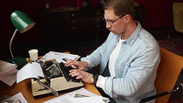 istock Cinematic writer scene - young man thinking at vintage typewriter 2209111706