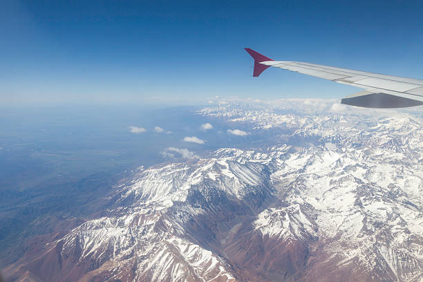 Aerial view of Chile's Andes reveals rugged peaks, valleys, and rivers.
