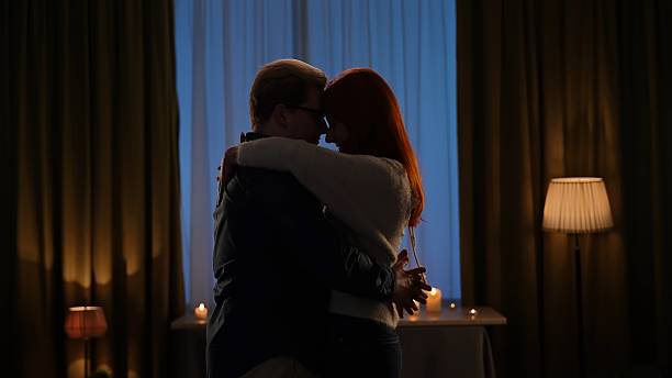 istock Romantic Couple Embracing in a Candlelit Room 2209116328